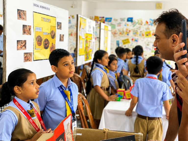 Student beside display boards on the Cognito 2026 theme, Celebrating Mistakes
